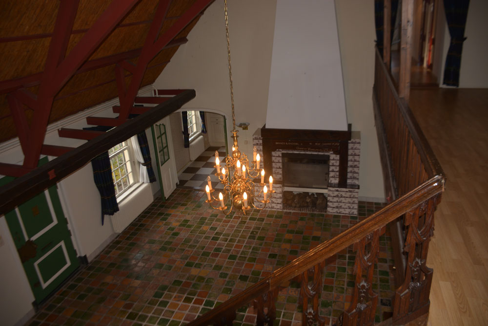 Centrale hal van de historische boerderij aan de Kniplaan in originele staat vóór restauratie, met trap, schouw en dakbalken