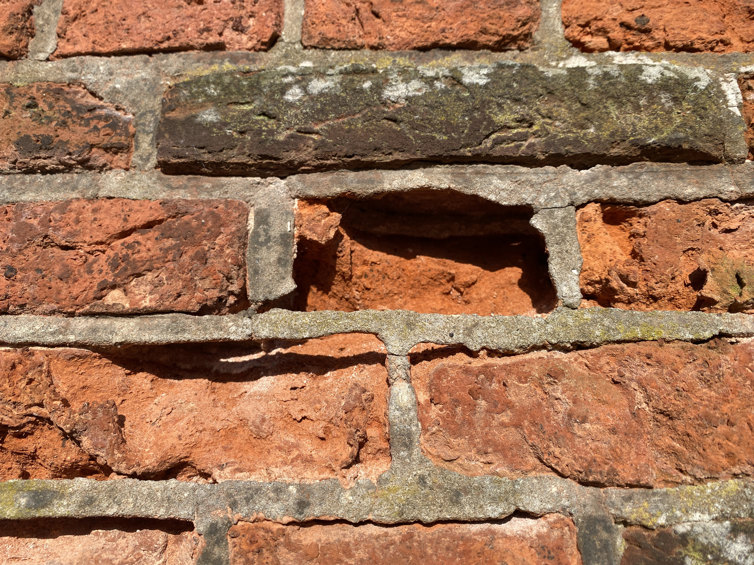 Close-up van cementgebonden voegen in de retranchementsmuur vóór restauratie